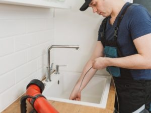 Plumber repairing leaking pipe